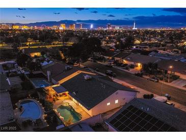 Expansive aerial view showcases a Las Vegas home with a private pool at twilight at 3057 Downing Pl, Las Vegas, NV 89121