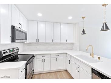 Modern kitchen with stainless steel appliances, white cabinets, and pendant lighting at 3339 Duece St, Las Vegas, NV 89121