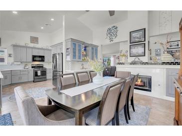 Open-concept kitchen and dining area with a fireplace and light gray cabinetry at 6109 Flaming Arrow Rd, North Las Vegas, NV 89031