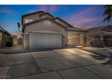 Two-story home with a wide driveway and two-car garage, set against a colorful twilight sky at 7308 Alpine Ridge St, Las Vegas, NV 89131