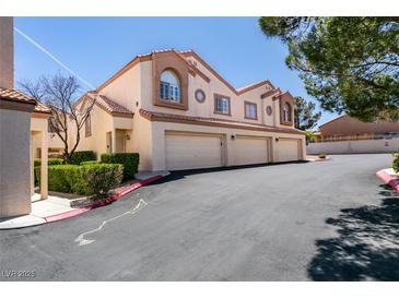 Inviting townhome featuring a three-car garage, desert landscaping, and a charming tiled roof at 8301 Boseck Dr # 215, Las Vegas, NV 89145