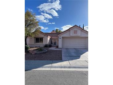 Charming single-story home with a well-manicured front yard, a two-car garage, and a red tile roof at 9421 Gold Mountain Dr, Las Vegas, NV 89134