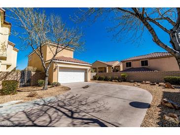 Two-story home with a two car garage and circular driveway complemented by well-manicured landscaping at 1016 Douglas Flat Pl, Las Vegas, NV 89138