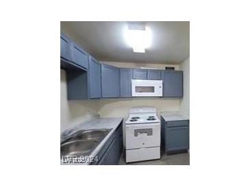 Cozy kitchen featuring blue cabinets, white appliances, and ample counter space at 304 Orland St # 39, Las Vegas, NV 89107