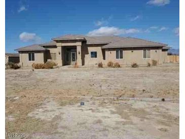 Single-story home featuring a desert landscape and a modern architectural design at 4320 Tiger Rd, Pahrump, NV 89048