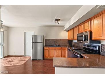 Well-lit kitchen featuring wood cabinets, stainless steel appliances, and sleek countertops at 5166 Gray Ln # M, Las Vegas, NV 89119