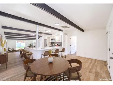 Bright living room featuring an open floor plan, beams, and wood flooring at 701 N Yale St, Las Vegas, NV 89107