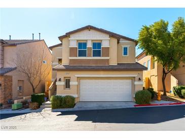 Two-story tan home features a two-car garage, charming architectural details, and well-maintained landscaping at 10745 Leatherstocking Ave, Las Vegas, NV 89166