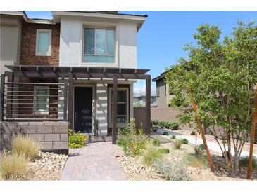 Charming two-story home featuring a modern exterior, pergola over the entrance, and drought-resistant landscaping at 11703 Emerald Lake Ave, Las Vegas, NV 89138