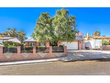 Charming single-story home featuring a brick fence, mature trees, and a two-car garage at 4095 Ridgewood Ave, Las Vegas, NV 89120