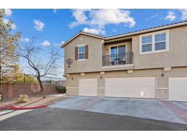 Three-story townhome featuring a balcony, three garage doors, and neutral color palette at 4305 Morgan Manor St # 3, North Las Vegas, NV 89032