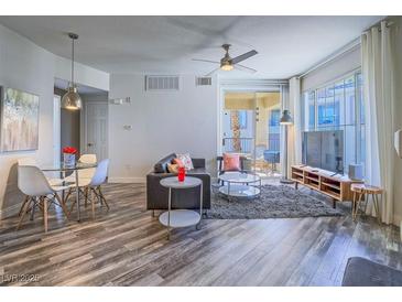Inviting living room with modern ceiling fan, dining area, and balcony access at 7111 S Durango Dr # 305, Las Vegas, NV 89113