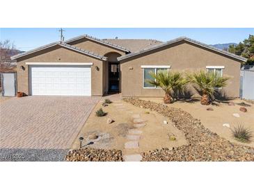 Charming single-story home features a well-maintained desert-style front yard with mature palm trees at 1000 E Enchanted Mesa St, Pahrump, NV 89048