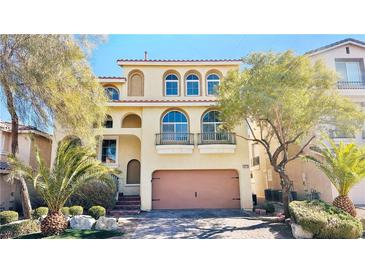 Charming two-story home with desert landscaping, a balcony, arched windows, and a terracotta-colored tile roof at 10716 Shasta Glow Ct, Henderson, NV 89052