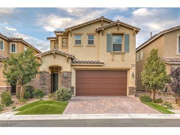 Charming two-story home featuring a well-manicured lawn, stone accents, and a brown two-car garage door at 3026 Coveri Ct, Las Vegas, NV 89141