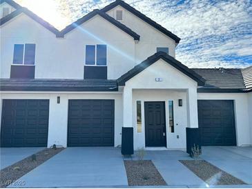 Modern two-story townhome showcasing dark garage doors and a sleek, minimalist design at 382 E Erin St # 2, Pahrump, NV 89048