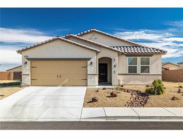 Charming single-story home featuring a beige facade, landscaped front yard, and a two-car garage at 3862 E Summit Ave, Pahrump, NV 89061