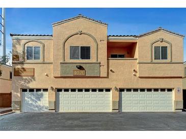 Inviting exterior featuring a multi-unit home with individual garages and peach stucco at 4020 Smokey Fog Ave # 201, North Las Vegas, NV 89081