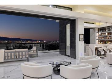 Modern living room with sleek bar and furniture, showcasing a city view through sliding glass doors at 667 Solitude Rock Ct, Henderson, NV 89012