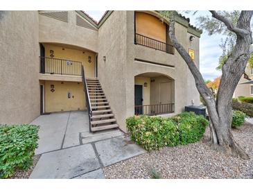 A close exterior view of a two-story condo building with access stairs and partial landscaping at 7885 W Flamingo Rd # 1016, Las Vegas, NV 89147