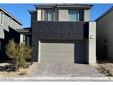 Modern two-story home featuring a two-car garage and brick paved driveway at 1586 Crowned Eagle St, Las Vegas, NV 89138