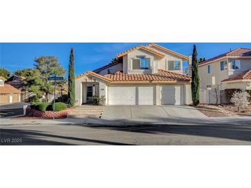 Charming two-story home featuring a terracotta roof, a three-car garage, and manicured landscaping at 1800 Summit Pointe Dr, Las Vegas, NV 89117