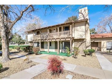 Charming two-story townhouse with a balcony, rustic columns, and a well-maintained front yard and landscaping at 3157 Pinehurst Dr # B, Las Vegas, NV 89109