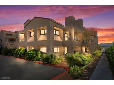 Exterior view of condo buildings with manicured shrubs and red sky sunset at 3883 Desert Marina Dr # 245, Laughlin, NV 89029