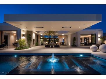 Stunning modern home exterior featuring a water feature and expansive covered patio at 41 Crested Cloud Way, Las Vegas, NV 89135