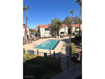 A refreshing swimming pool surrounded by palm trees, community buildings, and lounge chairs at 4854 Nara Vista Way # 201, Las Vegas, NV 89103