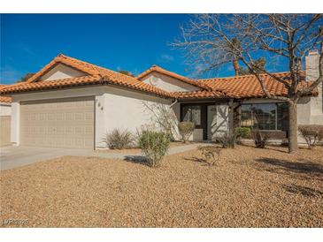 Charming single-story home featuring a tile roof, a well-maintained front yard, and an attached two-car garage at 764 Biaritz Ave, Las Vegas, NV 89123