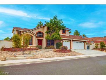 Charming two-story home featuring a tile roof, arched windows, and a well-manicured front yard at 1584 Bermuda Dunes Dr, Boulder City, NV 89005