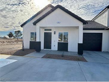 Charming single-story home boasts a modern design, two-car garage, and sleek black and white color palette at 388 E Erin St # 4, Pahrump, NV 89048