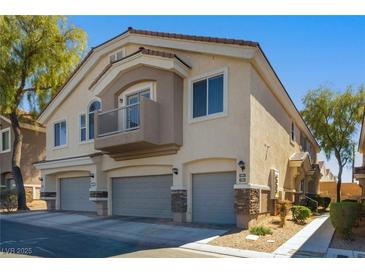Two-story home featuring multi-car garages, balcony and neutral toned stucco exterior at 6493 Za Zu Pitts Ave # 101, Las Vegas, NV 89122