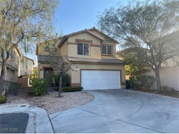 Tan two-story home with a two car garage and desert landscaping at 9299 Adamshurst Ave, Las Vegas, NV 89148