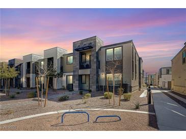 Beautiful modern townhome exterior featuring unique architecture with stone accents under a vibrant sunset at 1135 Tektite Ave, Henderson, NV 89011