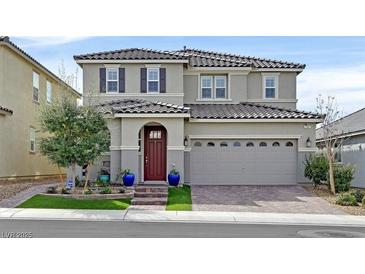 Charming two-story home with a well-manicured lawn and a brick driveway leading to a two-car garage at 2587 Tolmezzo St, Henderson, NV 89044