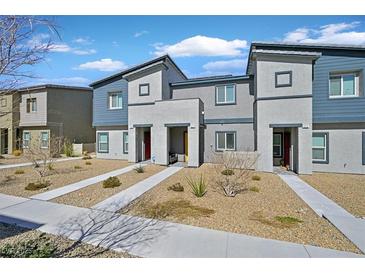 Modern townhome showcasing a gray facade, complemented by rock landscaping, a concrete walkway, and a blue sky backdrop at 527 Clearsable Ave, Henderson, NV 89044
