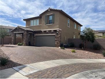 Beautiful two-story home featuring stone accents, a two-car garage, and a brick-paved driveway at 625 Honesty Ct, Henderson, NV 89011