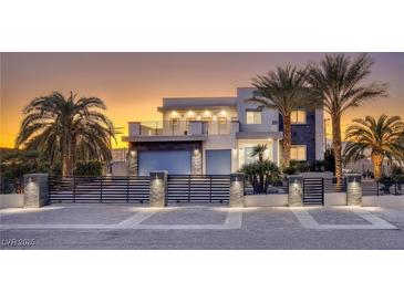 Stunning modern home featuring palm trees, sleek design, and a gated entrance at sunset at 675 Benedict Dr, Las Vegas, NV 89110