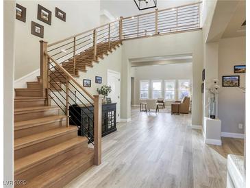 Bright entryway with wood staircase, modern railing, and open floor plan leads to the living room at 2737 Josephine Dr, Henderson, NV 89044