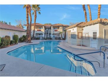 A refreshing community pool sparkles in front of the condominiums, framed by palm trees, in a tranquil outdoor setting at 3408 Winterhaven St # 204, Las Vegas, NV 89108
