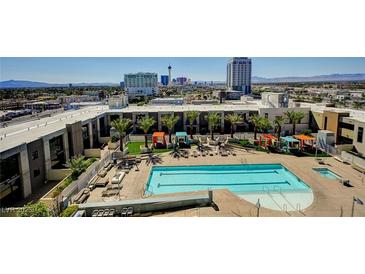 Bright aerial view of community pool area with lounge seating, poolside cabanas and mature landscaping at 353 E Bonneville Ave # 449, Las Vegas, NV 89101