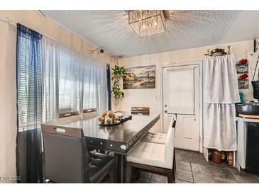 This dining area has a large table and a unique chandelier, perfect for Gathering meals at 4944 Rita Dr, Las Vegas, NV 89121