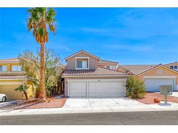 Charming two-story home featuring a two-car garage and landscaped front yard with a mature palm tree at 9505 Belgate Ct, Las Vegas, NV 89129