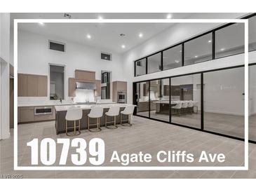 Modern, spacious kitchen with a large island, bar seating, stainless steel appliances, and plenty of natural light at 10739 Agate Cliffs Ave, Las Vegas, NV 89135