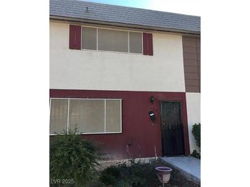 Two-story townhouse featuring neutral stucco, two windows and red trim at 146 Greenbriar Townhouse Way, Las Vegas, NV 89121