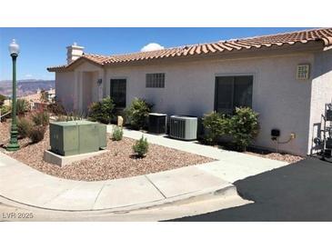 Beige single-story home with low maintenance landscaping, tile roof, and visible unit numbers near the entrance at 227 Big Horn Dr, Boulder City, NV 89005