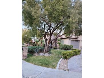Beautifully landscaped front yard with mature trees, lush green grass, and manicured shrubbery at 4738 Laurel Canyon St, Las Vegas, NV 89129