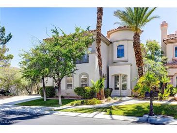 Charming two-story home with a stucco exterior, barrel tile roof, and lush desert landscaping at 52 Cascade Lake St, Las Vegas, NV 89148
